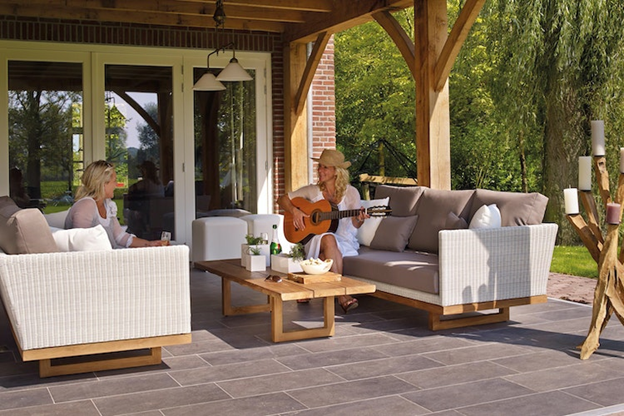 Woman with a guitar and another woman sitting on the patio